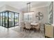 Dining room featuring modern light fixture and large windows with access to outdoor living at 7327 Summerland Cv, Bradenton, FL 34202