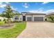 Beautiful home showcasing a well-manicured lawn, brick driveway, and a welcoming two-car garage at 7327 Summerland Cv, Bradenton, FL 34202