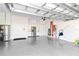 Spacious garage with white cabinets, stainless steel refrigerator, and epoxy flooring at 7327 Summerland Cv, Bradenton, FL 34202