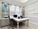 Bright and airy office space showcasing large desk, built-in shelving, and ample natural light at 7327 Summerland Cv, Bradenton, FL 34202