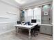 Bright office featuring custom shelving, a tray ceiling, and two workstations at 7327 Summerland Cv, Bradenton, FL 34202