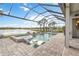 Stunning screened-in pool area with a spa, lake view, and comfortable lounge chairs at 7327 Summerland Cv, Bradenton, FL 34202