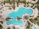 Aerial view of a large community pool with ample seating and tropical landscaping at 7327 Summerland Cv, Bradenton, FL 34202