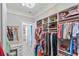 Bright walk-in closet featuring custom shelving for clothing and accessories, plus vanity at 7327 Summerland Cv, Bradenton, FL 34202