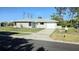 Well-maintained single-story home with a green lawn, tidy landscaping, and an attached garage at 7524 Kavanda St, North Port, FL 34287