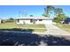 Charming single-story home with a well-maintained lawn and a driveway leading to an attached garage at 7524 Kavanda St, North Port, FL 34287