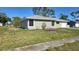 Well-maintained single-story home with a green lawn, tidy landscaping, and an attached garage at 7524 Kavanda St, North Port, FL 34287