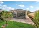 View of the backyard with green lawn, patio, and tropical foliage in a serene setting at 7632 Quinto Dr, Sarasota, FL 34238