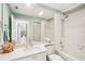 Well-lit bathroom featuring a shower-tub combo with white tiling, a large mirror, and fresh, decorative accents at 7632 Quinto Dr, Sarasota, FL 34238