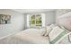 Sunlit bedroom with a large window and garden view, decorated with a calm color palette for a relaxing ambiance at 7632 Quinto Dr, Sarasota, FL 34238