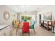 Bright dining area with colorful chairs, modern chandelier, and sliding glass doors leading to the outdoor patio at 7632 Quinto Dr, Sarasota, FL 34238