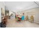 Open-concept dining area with a modern chandelier, colorful chairs, and wood-look tile flooring at 7632 Quinto Dr, Sarasota, FL 34238