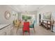 Open dining room with a modern chandelier, colorful chairs, and sliding glass doors to the patio at 7632 Quinto Dr, Sarasota, FL 34238