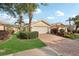 Well-manicured villa showcases a brick driveway, lush landscaping, and a spacious two-car garage at 7632 Quinto Dr, Sarasota, FL 34238