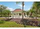 Picturesque gazebo overlooking a serene lake with a fountain, surrounded by lush landscaping and palm trees at 7632 Quinto Dr, Sarasota, FL 34238