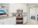 Modern kitchen features stainless steel appliances, white cabinets, sleek countertops, and a view to the living room at 7632 Quinto Dr, Sarasota, FL 34238
