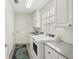 This is a laundry room with front loading washer and dryer and utility sink at 7632 Quinto Dr, Sarasota, FL 34238