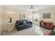 Cozy living room features a comfortable blue sofa, a ceiling fan, and bright, natural light at 7632 Quinto Dr, Sarasota, FL 34238