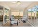 Comfortable screened patio with ceiling fan, seating area, and bright natural light at 7632 Quinto Dr, Sarasota, FL 34238
