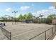 Well-maintained tennis court surrounded by fencing and lush greenery at 7632 Quinto Dr, Sarasota, FL 34238