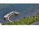 An aerial view of the dock and boats that sit on the water surrounded by lush green trees at 8779 Midnight Pass Rd # 506H, Sarasota, FL 34242