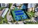 Aerial view showcases community tennis and pickleball courts surrounded by lush greenery and amenities at 8779 Midnight Pass Rd # 506H, Sarasota, FL 34242