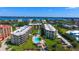 Aerial view of waterfront condos, a pool, and lush landscaping at 8779 Midnight Pass Rd # 506H, Sarasota, FL 34242