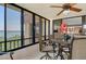 This cozy screened balcony has water views and a ceiling fan above the dining table at 8779 Midnight Pass Rd # 506H, Sarasota, FL 34242
