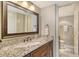 Bathroom featuring granite countertops, wood cabinets and modern bronze fixtures at 8779 Midnight Pass Rd # 506H, Sarasota, FL 34242