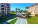 A view of the community pool with palm trees and shuffleboard at 8779 Midnight Pass Rd # 506H, Sarasota, FL 34242