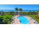 Community pool and path to the beach, complete with lounge chairs, palm trees, and blue skies at 8779 Midnight Pass Rd # 506H, Sarasota, FL 34242