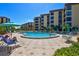 Exterior view of the community pool in front of Island Reef complex on a clear, sunny day at 8779 Midnight Pass Rd # 506H, Sarasota, FL 34242