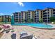 Exterior view of the community pool with the building in the background at 8779 Midnight Pass Rd # 506H, Sarasota, FL 34242