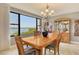 Bright dining room showcasing water views from large windows and a wooden dining table set at 8779 Midnight Pass Rd # 506H, Sarasota, FL 34242