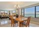 Bright dining room features water views, wood table, and connects to the living room at 8779 Midnight Pass Rd # 506H, Sarasota, FL 34242