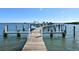 Long wooden dock with multiple boat slips extending into open water on a sunny day at 8779 Midnight Pass Rd # 506H, Sarasota, FL 34242