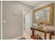 Condo entryway with a wooden table, ornate mirror, and view to the kitchen at 8779 Midnight Pass Rd # 506H, Sarasota, FL 34242