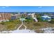 A group of buildings with a pool near a sandy beach on a sunny day at 8779 Midnight Pass Rd # 506H, Sarasota, FL 34242