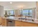 Spacious kitchen with stainless steel appliances and wood cabinetry open to living area with waterfront views at 8779 Midnight Pass Rd # 506H, Sarasota, FL 34242