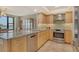 Open kitchen with stainless steel appliances and wood cabinetry overlooking the dining area at 8779 Midnight Pass Rd # 506H, Sarasota, FL 34242