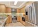 Modern kitchen featuring stainless steel appliances, light wood cabinets, and marble countertops at 8779 Midnight Pass Rd # 506H, Sarasota, FL 34242
