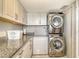 Well-organized laundry room equipped with modern washer, dryer, and granite countertops for folding at 8779 Midnight Pass Rd # 506H, Sarasota, FL 34242