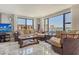 Bright living room offers water views through large windows and comfortable, stylish furnishings at 8779 Midnight Pass Rd # 506H, Sarasota, FL 34242