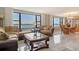 Bright living room showcases water views from large windows and connects to a dining area at 8779 Midnight Pass Rd # 506H, Sarasota, FL 34242