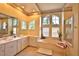 Bathroom with double sinks, large tub, and lots of natural light, surrounded by decorative wallpaper border at 950 Trotter St, Nokomis, FL 34275