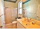 Well-lit bathroom featuring a shower with sliding glass doors and a peach vanity area with a large mirror at 950 Trotter St, Nokomis, FL 34275