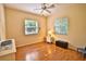 Bedroom with wood floors, a ceiling fan, two windows with blinds, and furniture at 950 Trotter St, Nokomis, FL 34275