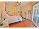Bright bedroom with wood floors, white furniture, and sliding glass doors to a patio at 950 Trotter St, Nokomis, FL 34275