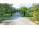 Gated entry to a long driveway leading to the house, ensuring privacy at 950 Trotter St, Nokomis, FL 34275