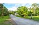 Long driveway leads to a well-maintained home surrounded by green lawns at 950 Trotter St, Nokomis, FL 34275